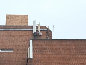 Image of telecommunication antennas on the rooftop of a building, TV aerial can also be seen